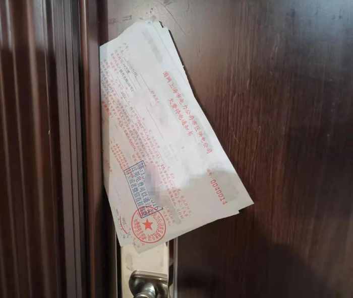 金富得公寓一户门口的欠费单 余继超摄