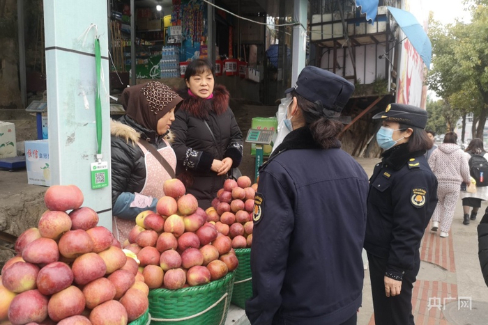 城市综合执法队员与流动摊主交流（央广网发 任振国 摄）