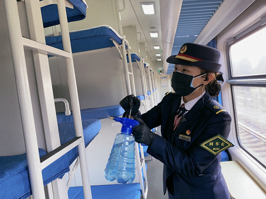     郑州客运段把旅客列车常态化疫情防控作为重中之重的工作。图为23岁的北京一队K180次列车长宋艺洁在车内喷洒消毒液。孟帅/摄