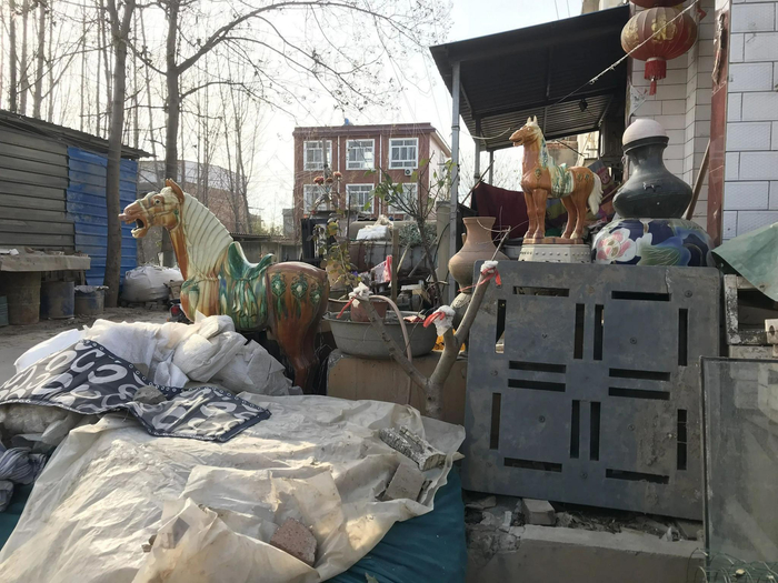 ▲12月7日，洛阳市附近的村庄，仿制的文玩工艺品堆在路边。新京报记者 聂辉 摄