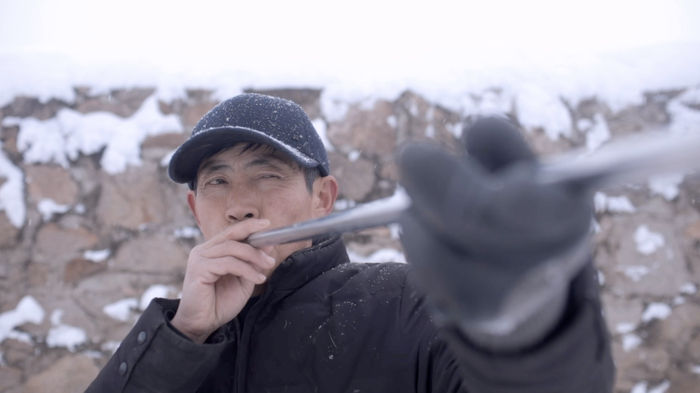 鹿场老人正在吹麻药。