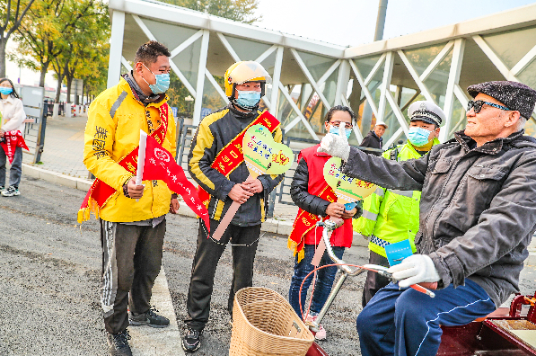外卖小哥化身“小巷管家”参与路口值守。本报记者 武亦彬摄