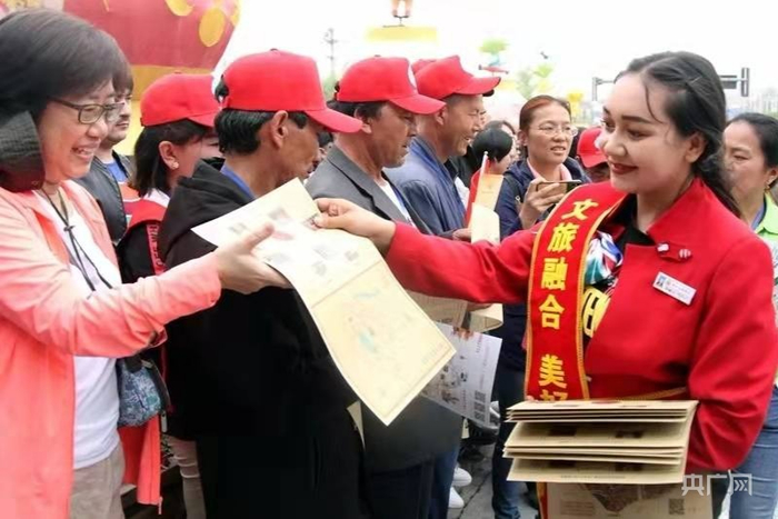 导游为游客发放宣传资料。王振强   摄 央广网发
