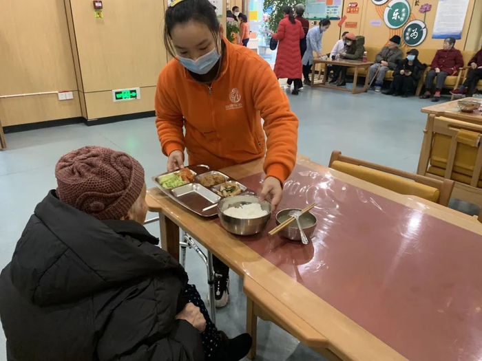 工作人员为行动不便的老人送餐 陈骅 摄
