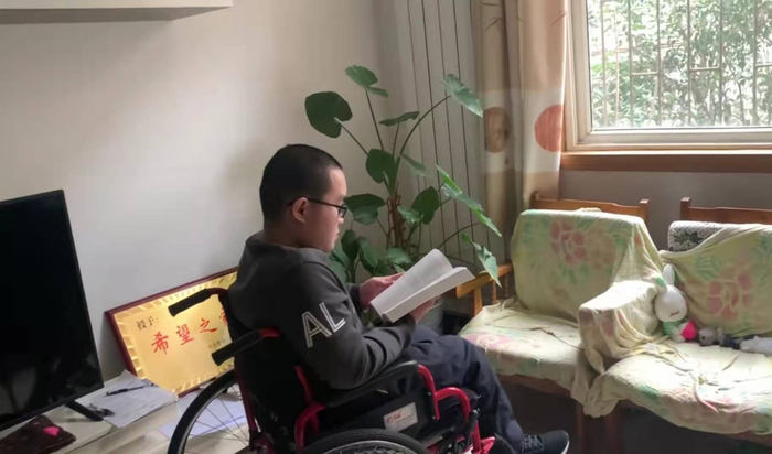 杨某科因下肢残疾坐轮椅。来源：新京报我们视频截图