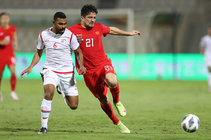 11月11日，中国队球员洛国富（右）与阿曼队球员艾哈迈德·哈米西在比赛中拼抢。新华社发