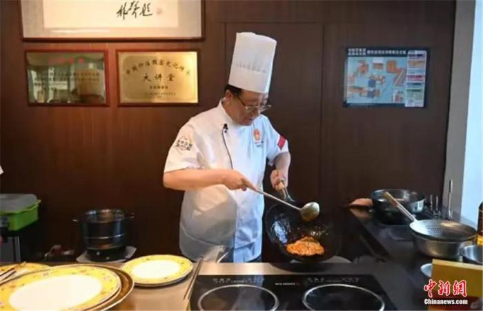 刘敬贤展示烹饪技巧。中新社记者 于海洋 摄