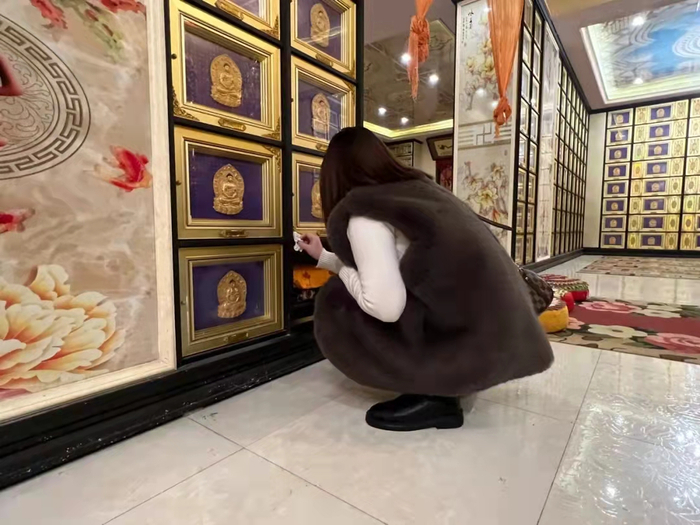 11月2日，陈美霖在孩子们的周年忌日前往寺庙，一遍遍擦拭着骨灰盒。新京报记者 杨雪 摄