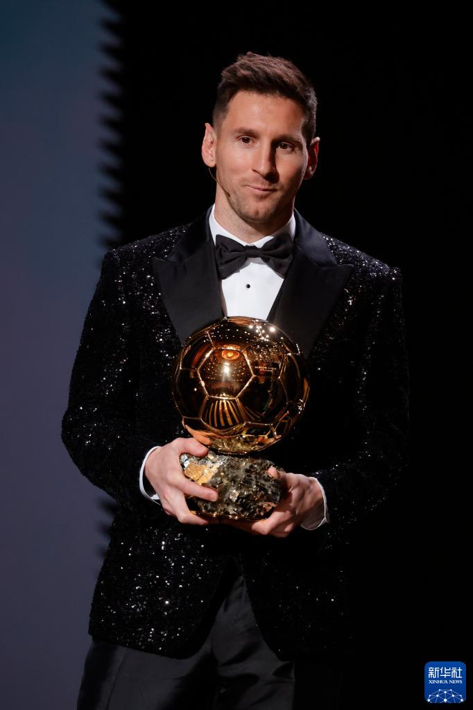 这是2021年11月29日，梅西在由《法国足球》杂志主办的2021年金球奖颁奖典礼上手捧金球奖奖杯。阿根廷球星梅西在评选中击败一众对手，创纪录地第七次获得这一奖项。新华社发（亨利·斯瓦尔克 摄）