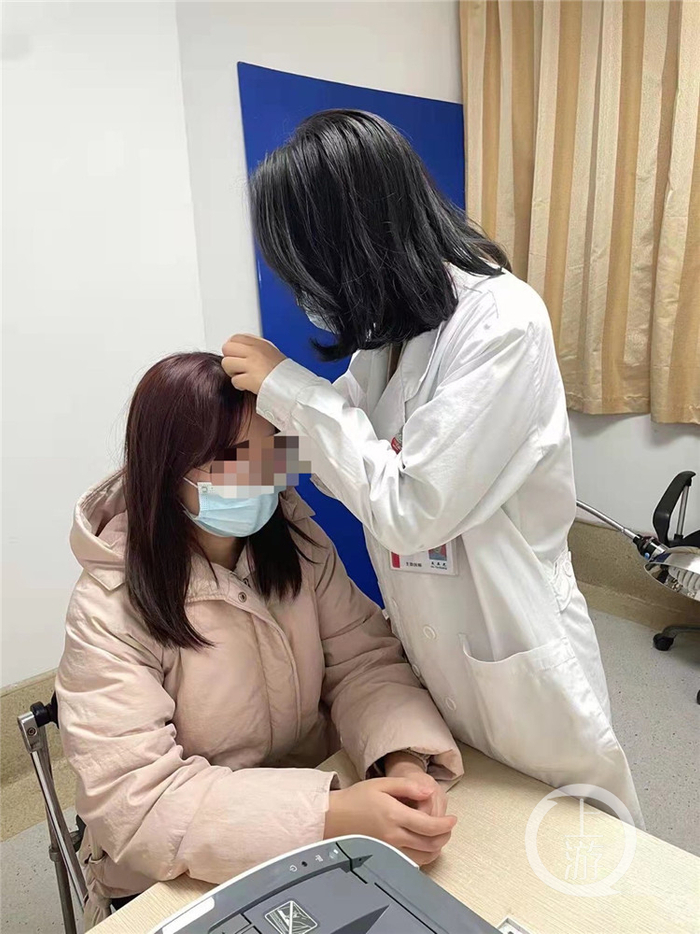 △西南医院皮肤科，医生正在为一位二十多岁的脱发姑娘看诊