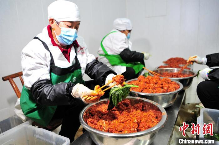 工人用菜叶包裹腐乳。　张国荣 摄