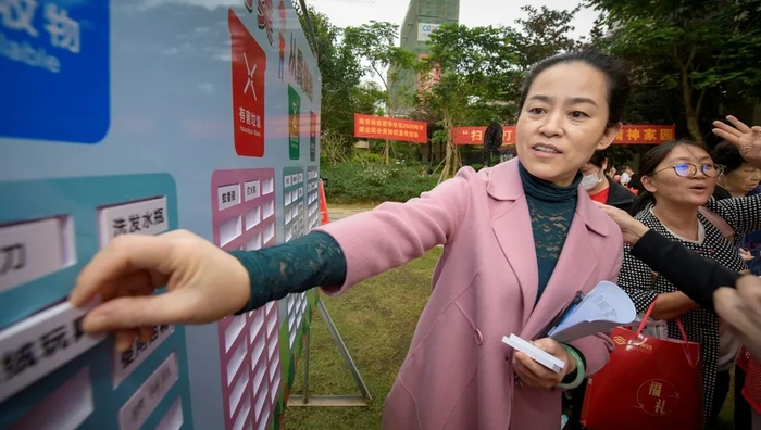 ▲2020年12月26日，海口市秀英区爱华社区开展元旦游园会，社区居民在游园会上体验垃圾分类填空小游戏。