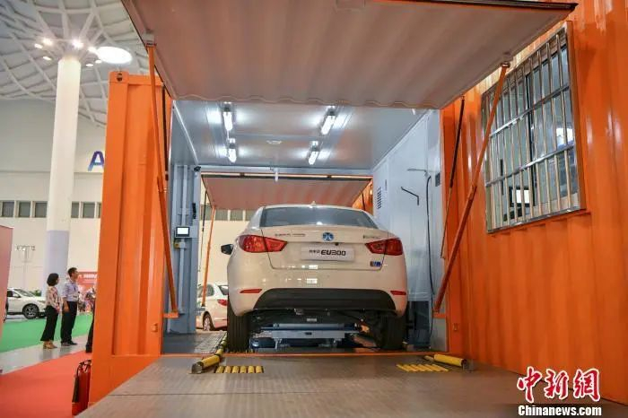 图为一辆纯电汽车正在演示更换蓄电池。骆云飞 摄