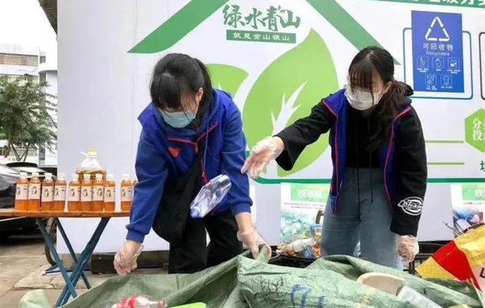 ▲2020年12月26日，海南大学大二学生邹家怡来到位于海口龙华区金宇街道金地路的“三无小区”金成绿苑小区开展志愿服务，和居民一起将可回收垃圾二次分拣。