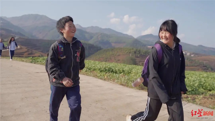 ▲走在返校路上的王福满和姐姐