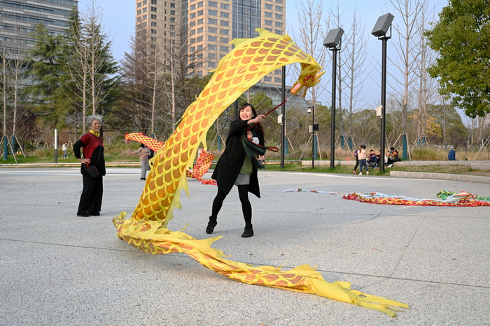 2021年12月11日，苏州河二号滨河绿地，周馨与采访对象互动玩健身龙。