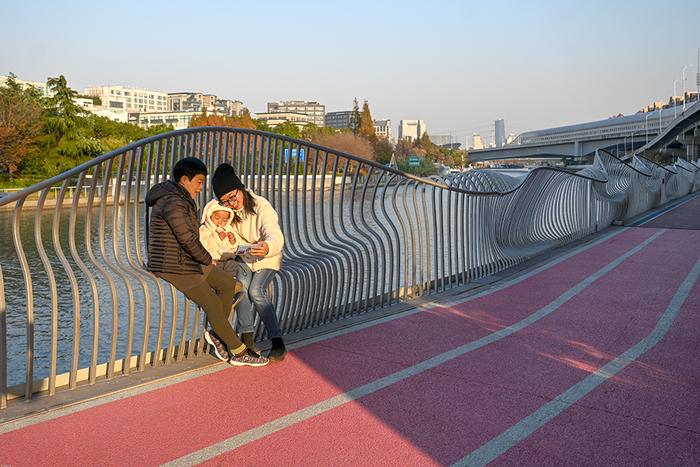 2021年12月3日，苏州河中环立交桥段，陈洁和妈妈、儿子在河边长凳上休息。