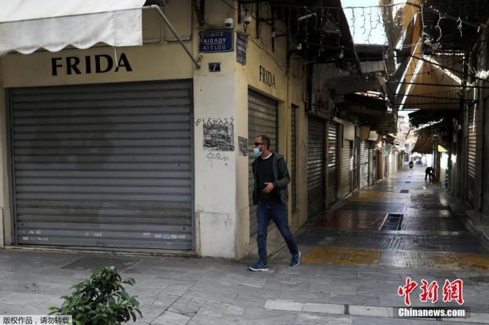 资料图：当地时间2020年11月7日，希腊雅典，行人经过关闭的商业街。