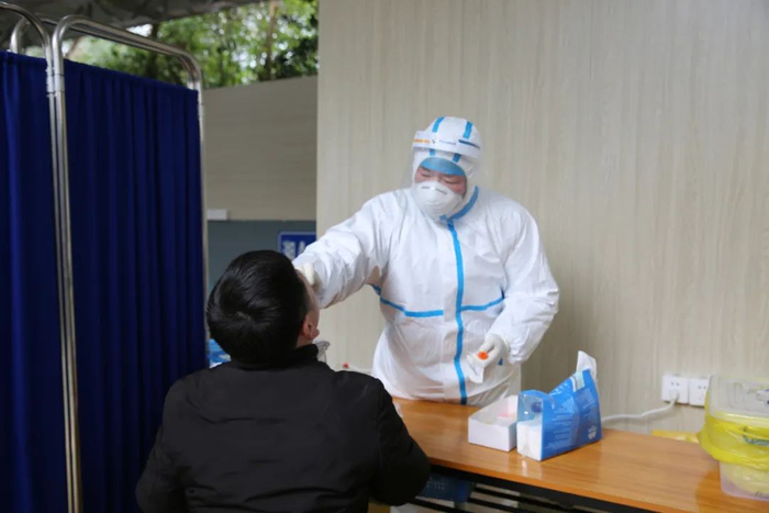 医生为打算返乡的人员开展核酸检测。粟青梅 摄
