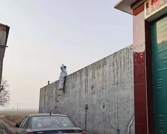 1月22日，小果庄，喂狗队的一名队员正在墙外投喂馒头。&nbsp;候杰/摄