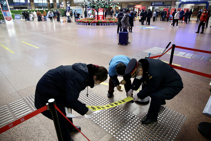 北京西站，工作人员更换破损的“一米线”。新京报记者 王贵彬 摄