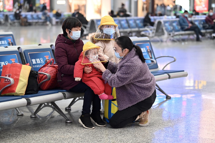 1月28日，上海虹桥火车站，凌女士在给孩子整理口罩。由于工作原因，凌女士还不能确定能否回家过年，只能由凌女士的母亲先带着两个孩子回湖南老家。