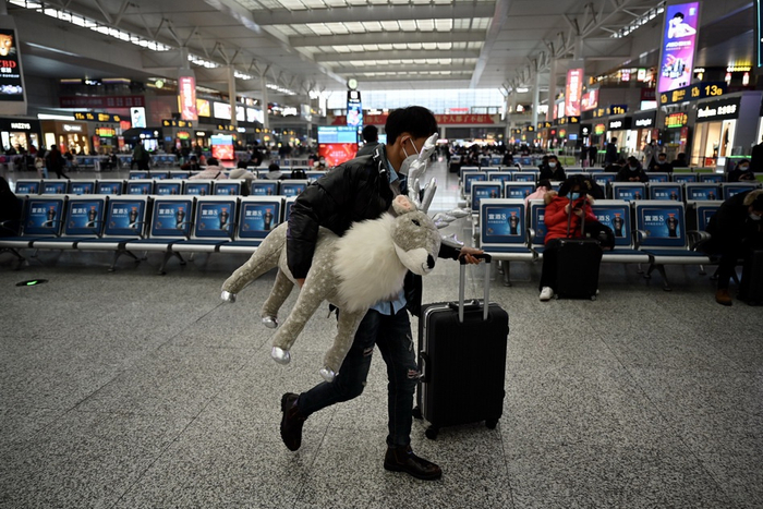 1月28日，上海虹桥火车站，徐先生抱着送给女儿的毛绒玩具赶往进站口。受疫情影响，作为外卖小哥的徐先生2020年只回过一次家，他说，这次过年无论如何也要回家看看妻儿老小。