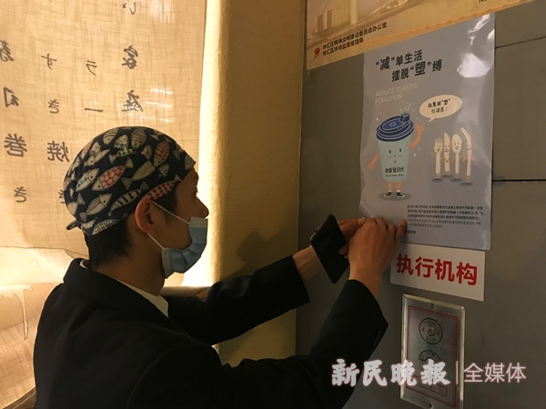 图说：在一家名叫“渔上”的日料店内，工作人员正在张贴“限塑”宣传单