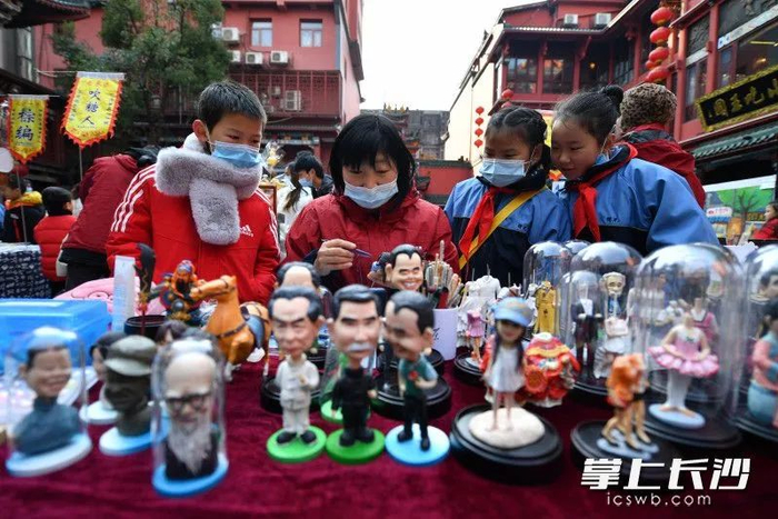 △坡子街上，非遗项目的店铺吸引了学生们驻足围观。