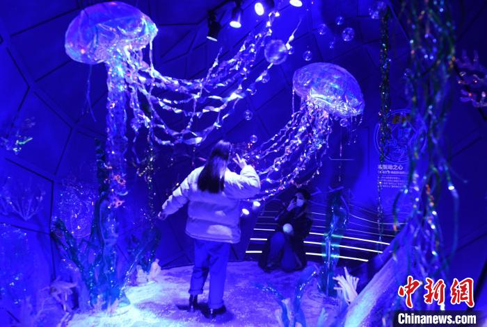 图为各种环保材料打造的海底世界吸引市民拍照留念。　周毅 摄