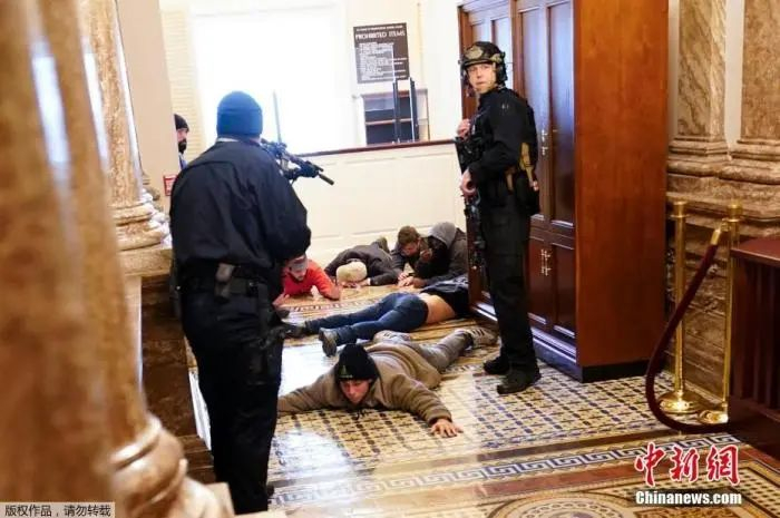 当地时间1月6日，美国参众两院确认选举人团投票结果的联席会议，因现任总统特朗普支持者闯入国会大厦而被迫中断，现场极度混乱。图为被制服的特朗普支持者。