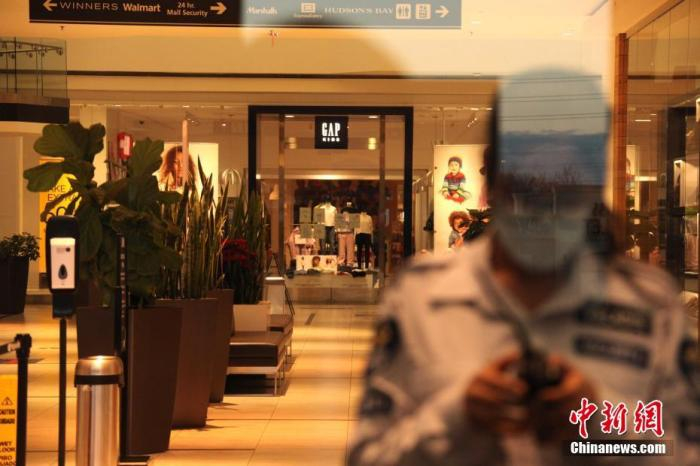 资料图：当地时间12月14日，加拿大大多伦多地区万锦市（Markham）一座购物中心内几无顾客，安保人员仅允许预约取货者入内。 中新社记者 余瑞冬 摄