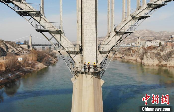 图为职工们在桥中间巡检。　高展 摄