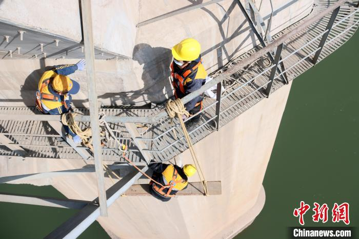 兰州西桥隧车间副主任胡跃武悬挂于半空中，列车头顶经过，吊板靠在桥墩上像荡秋千一样摇来晃去。　王光辉 摄