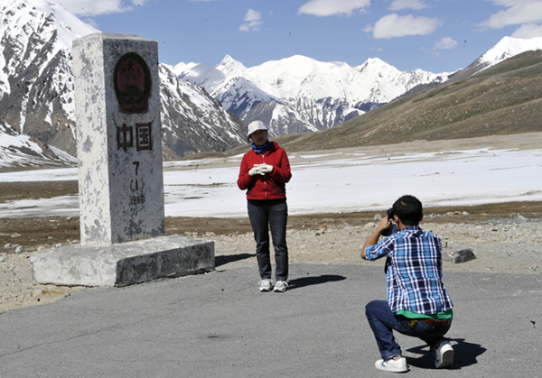 位于新疆塔什库尔干塔吉克自治县的中国、巴基斯坦边境线上，游客与界碑合影。图|新华社