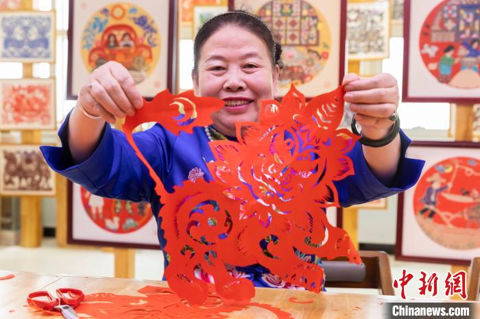 伏兆娥展示剪纸作品“年兽”。　杨迪　摄