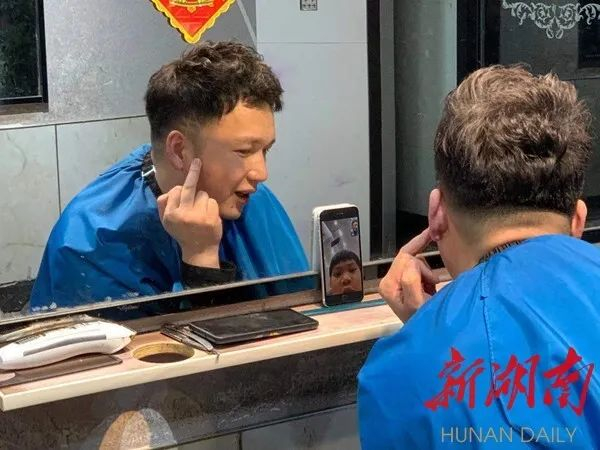 △肖明明向儿子肖恩展示他的“牛”字发型，并为他加油鼓劲