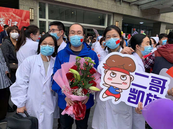 资料图：吴祎（手持鲜花者）援鄂解除隔离观察后回到医院 采访对象供图
