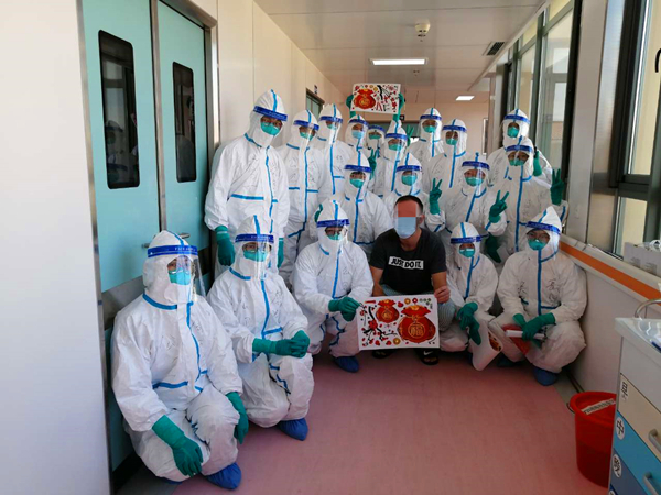 图说：医护人员和出院患者合影 采访对象供图