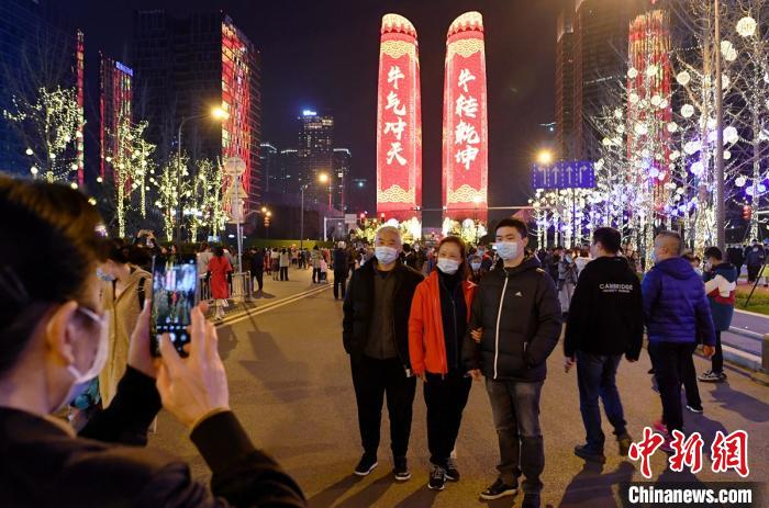 民众在双子塔灯光秀现场合影留念。　刘忠俊 摄