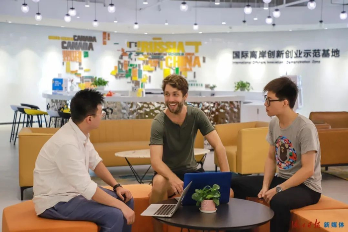 在复兴城国际离岸创新创业示范基地，外籍工作者与同事交谈。王程龙摄