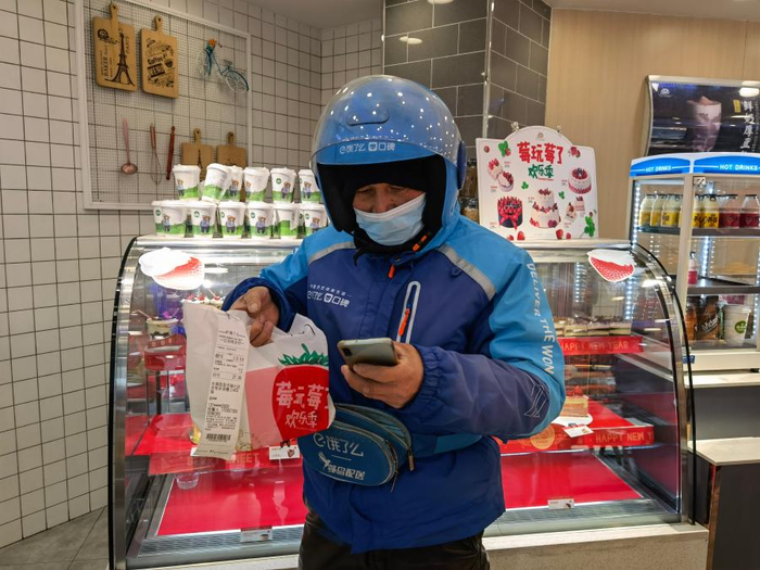 正在取餐的杨书生，春节期间，他依旧留在合肥，坚守在岗位上。新华社记者 马姝瑞 摄