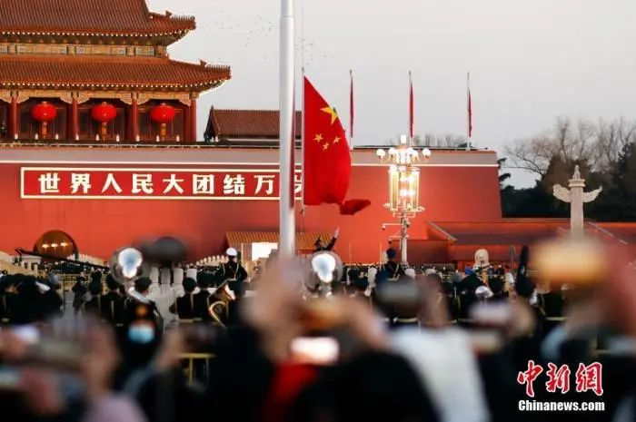 资料图：1月1日晨，北京天安门广场举行隆重的升国旗仪式。图为民众观看、拍摄升旗仪式。中新社记者 盛佳鹏 摄