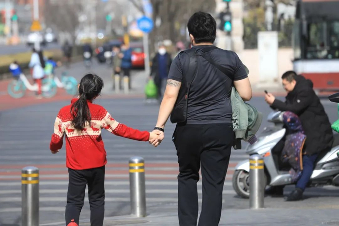 ▲2021年2月21日，北京，市民纷纷穿着“夏装”行走在路上。图源/IC photo