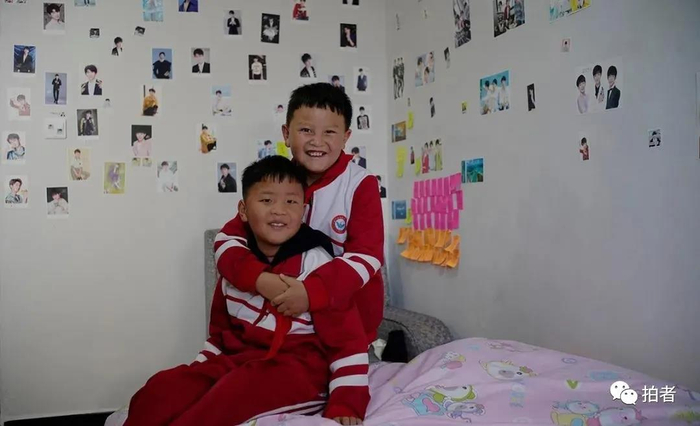 △ 2020年6月9日，毕节市威宁县五里岗街道，张鹏和张健在新家的卧室里合影。兄弟俩就读于威宁县第七小学，他们的姐姐就读于附近的初中和高中，在外地打工的父母均返乡就业。摄影 / 新京报记者陈杰