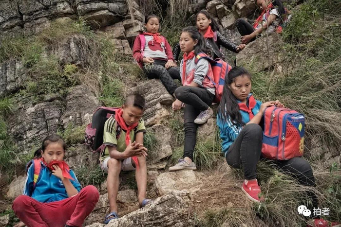 △ 2016年5月14日，四川省凉山彝族自治州“悬崖村”，孩子们在攀爬过程中，聚集在狭窄的崖壁上休息，整个路程，大部分休息的地方处在悬崖边，空间狭小。摄影 / 新京报记者陈杰
