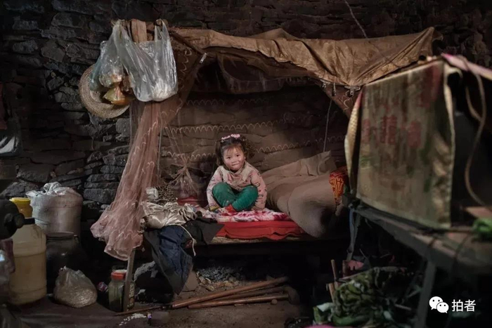 △ 2017年12月14日，贵州省哲觉镇论河村，4岁的张琴在和奶奶一起睡的床上，她的家地处深山，为深度贫困户。2017年，她家被纳入精准扶贫户。摄影 / 新京报记者陈杰