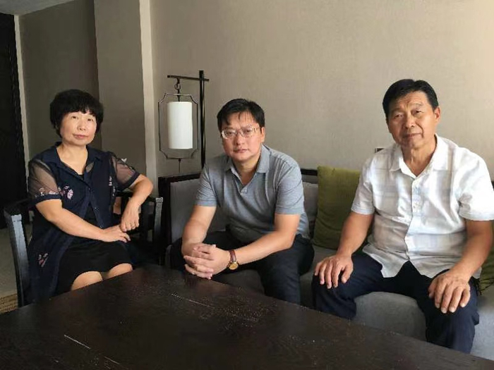 案件一审开庭前，杜新枝、郭希宽（右）与代理律师。受访者供图