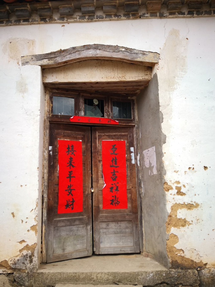 　与外墙并不齐平的木门，门边裸露的水泥明显看出改门的痕迹。