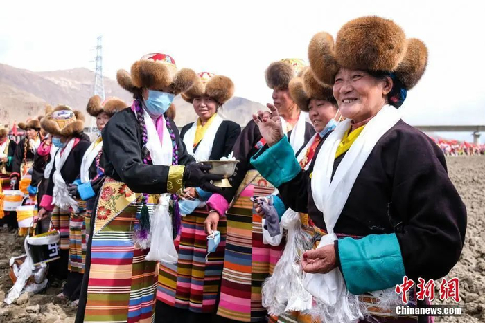 资料图：西藏自治区拉萨市曲水县才纳乡协荣村参加春耕仪式的村民互敬青稞酒。按照传统，当地村民身着节日盛装，举行隆重的仪式，祈福一年的丰收。中新社记者 何蓬磊 摄